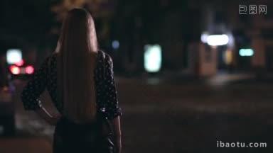背影迷人的女孩搭车在城市街道在夜晚背景大的城市灯光